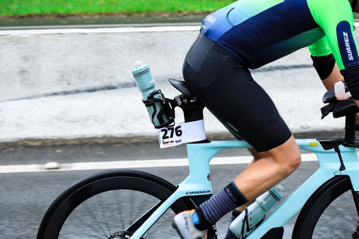 Close-up of a triathlete pedalling a race bike with a drinks bottle in the frame cage